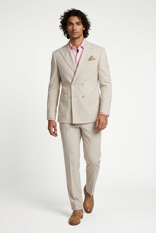 Man wearing a beige suit with a pink shirt on a white background