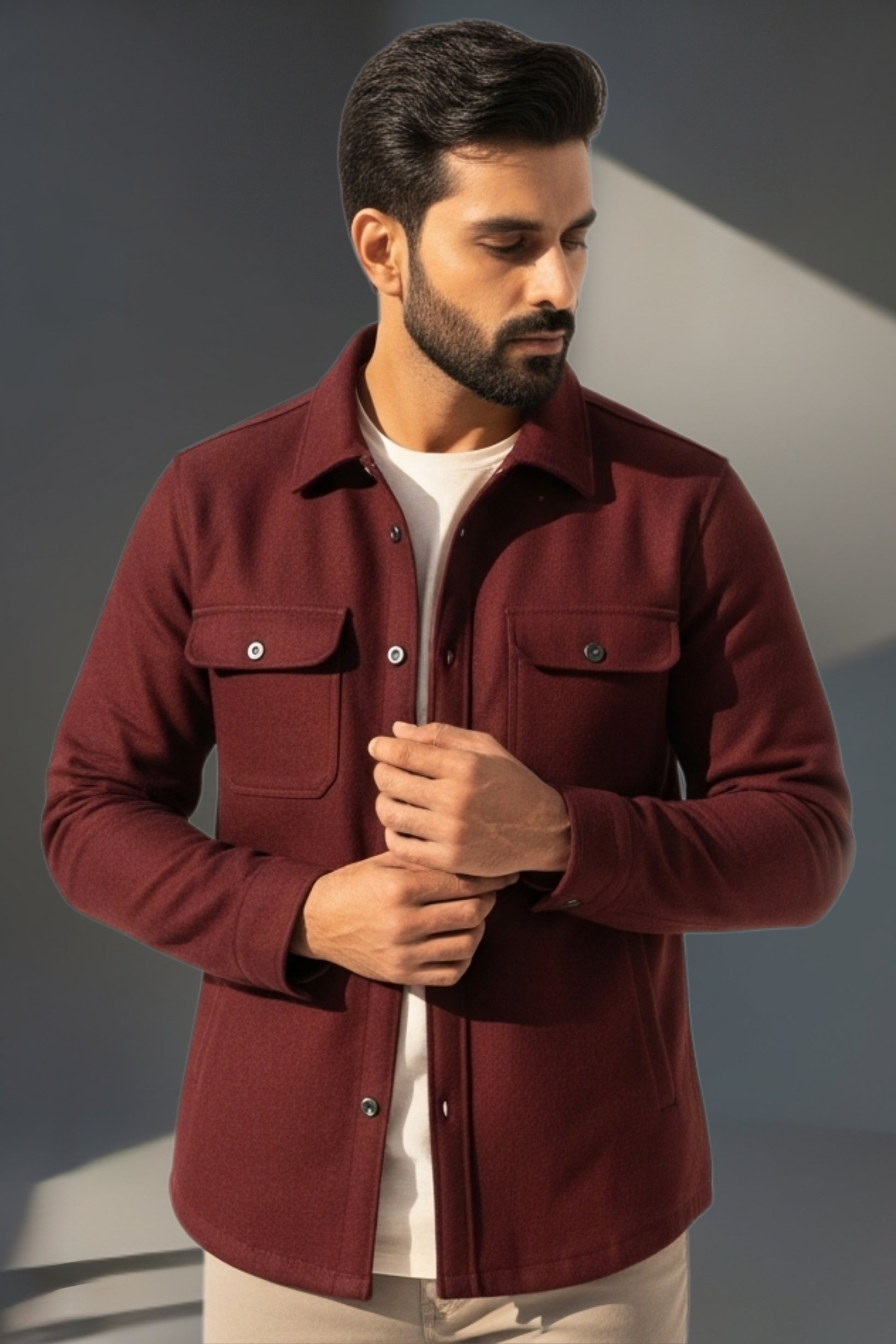 Man wearing a burgundy jacket against a gray background