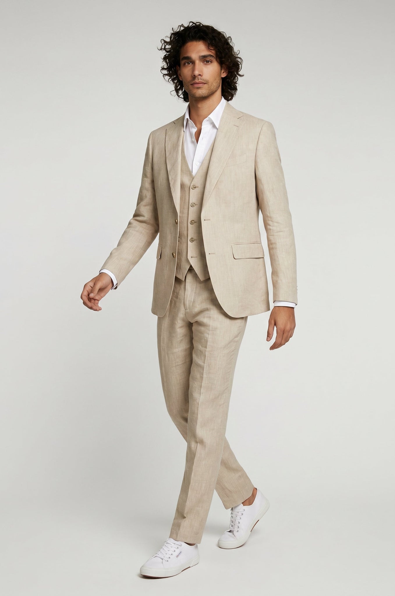 Man wearing a beige suit with a white shirt on a light gray background
