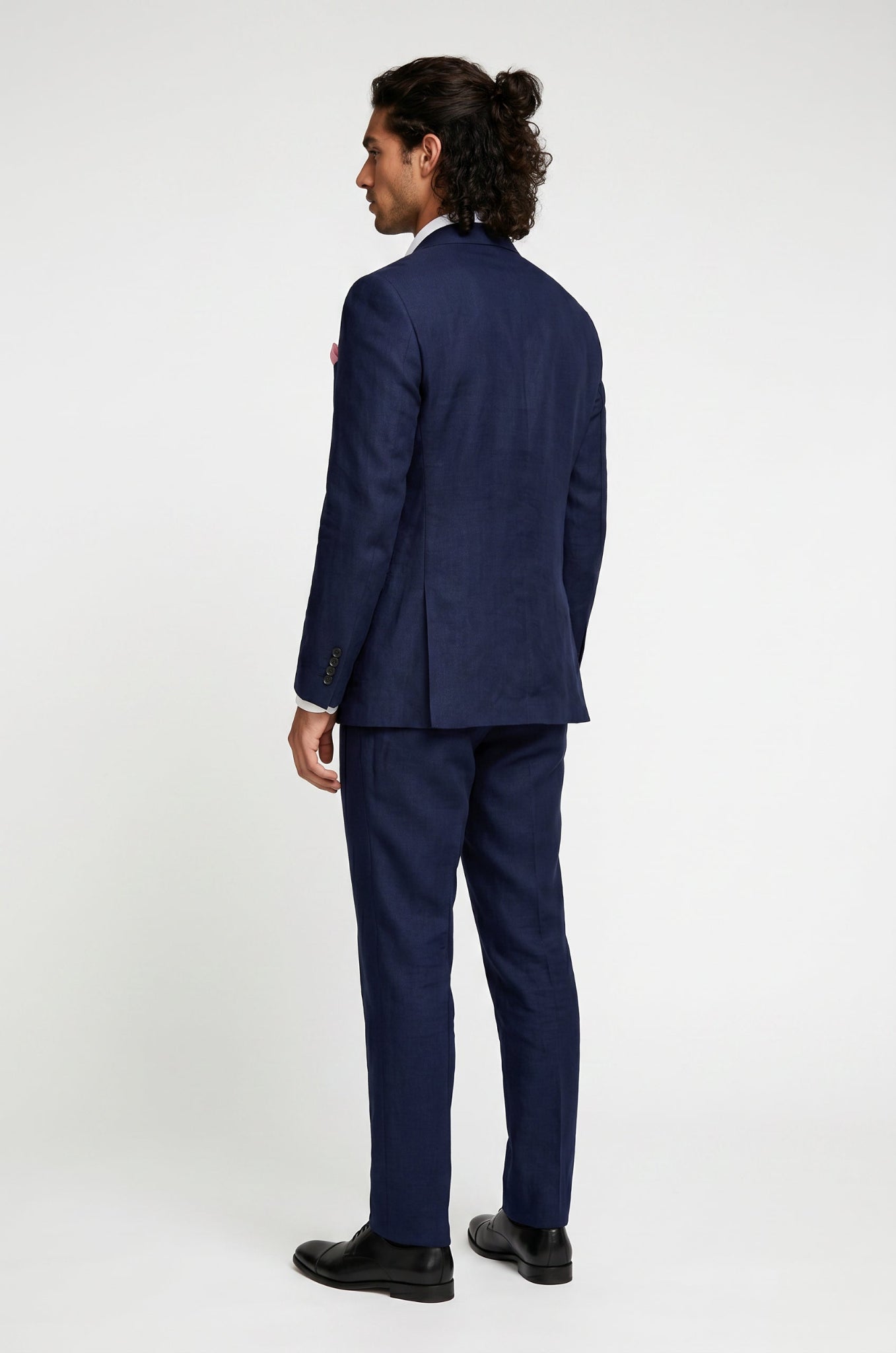 Man wearing a navy linen suit on a white background