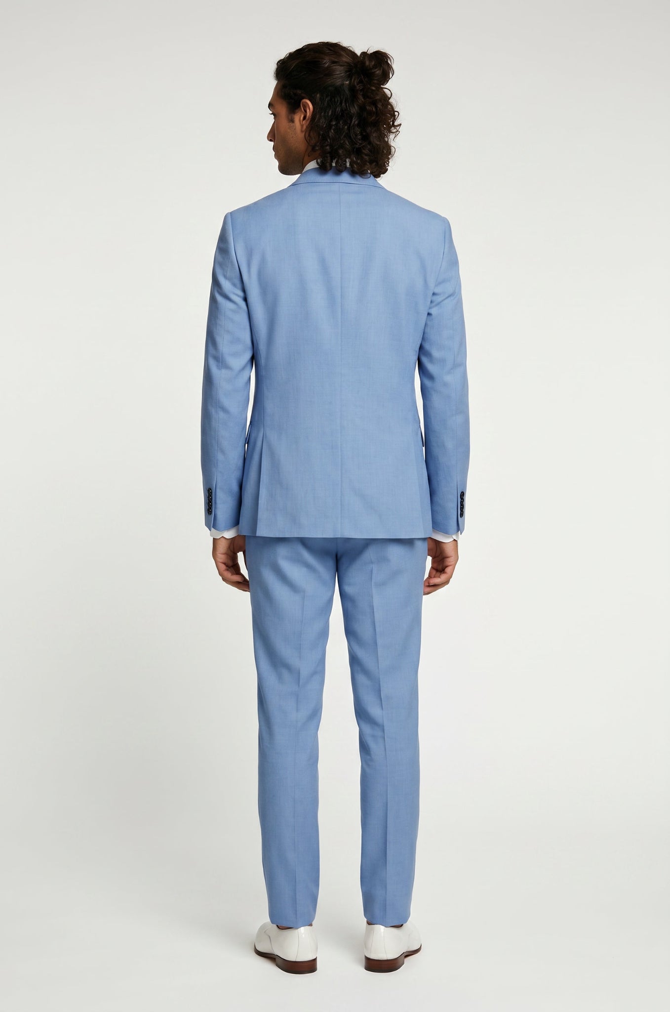 Man wearing a light blue linen suit on a white background