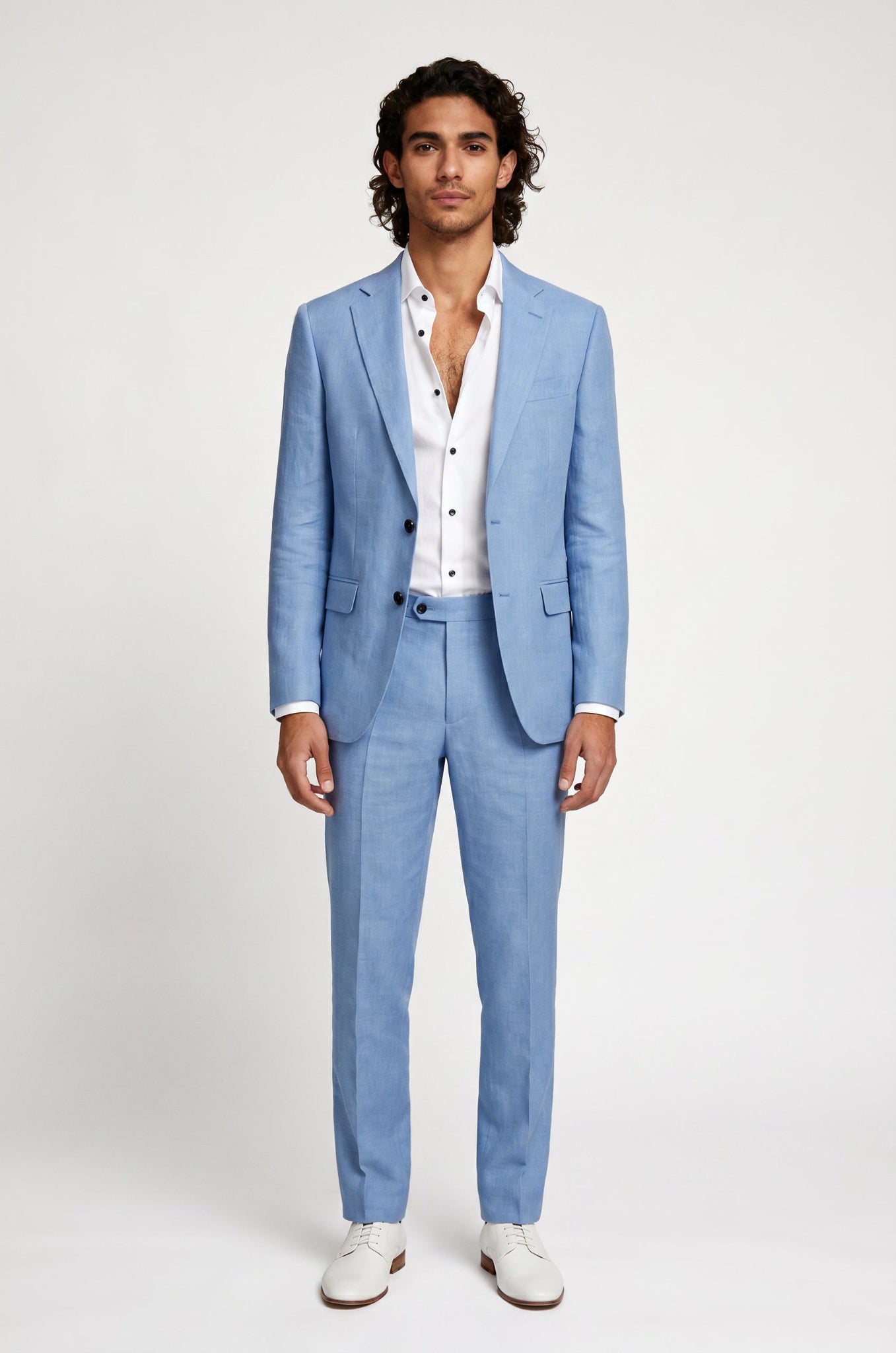 Man wearing a light blue linen suit with a white shirt on a plain background