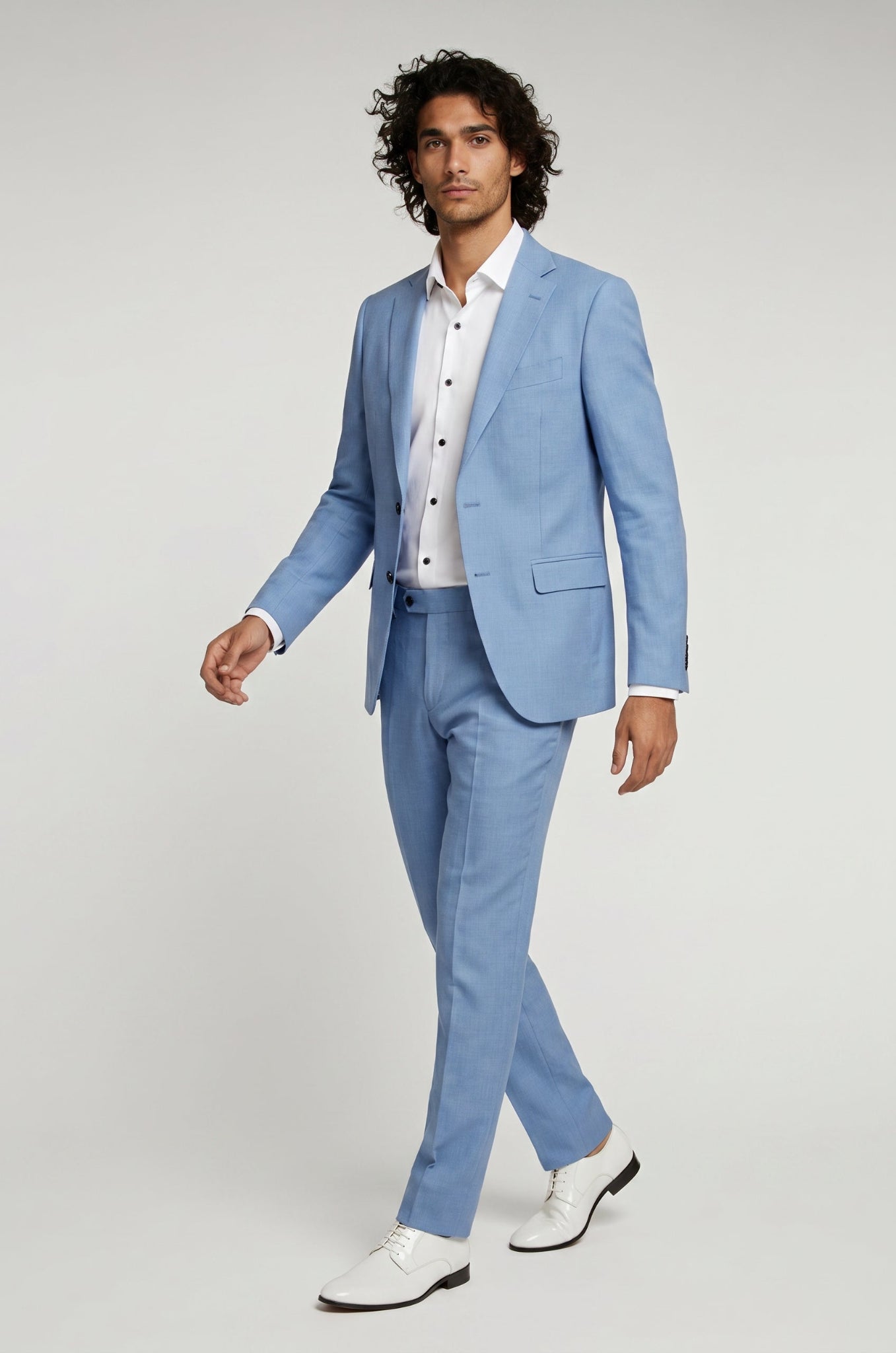 Man wearing a light blue suit with a white shirt on a gray background
