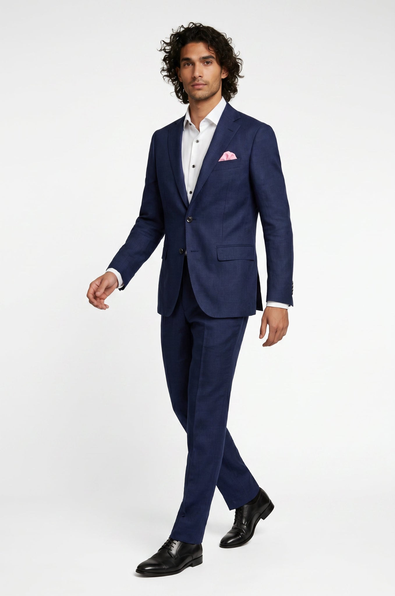 Man wearing a blue suit with a white shirt and pink pocket square on a white background
